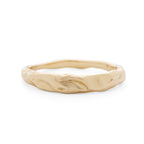 Gold ring with a textured band on a white background