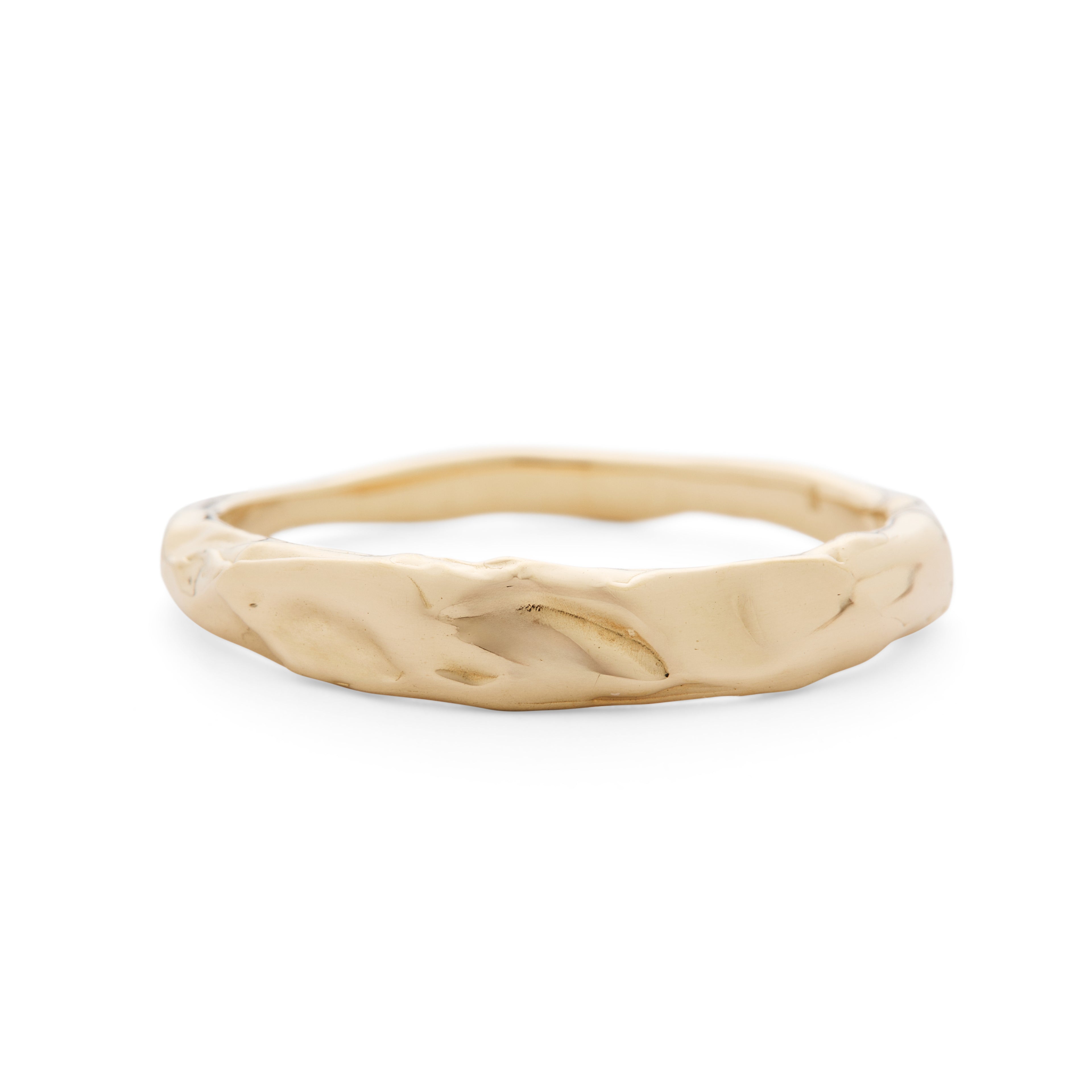 Gold ring with a textured band on a white background